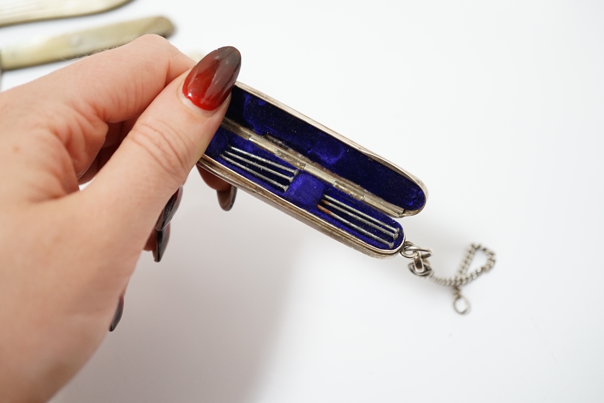 A collection of six assorted Victorian mother of pearl and silver bladed pocket fruit knives, a similar white metal fruit knife and a silver pin case. Condition - poor to fair